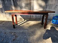 Front view of the closed console table showing polished mahogany wood and clean rectangular tabletop with parquetry inlay.