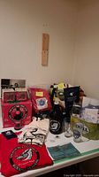 Photo showing two packets of coasters, shirts, and various beer memorabilia items spread on a table.