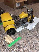 Side angle showing the full metal replica with yellow painted parts and rear storage box.