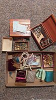 Overview shot of the lot showing jewelry boxes, pearl-like necklaces and assorted pins