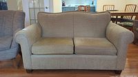 Front view of loveseat showing two seat cushions and rolled arms