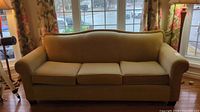 Front view of the sofa showing overall condition and beige color