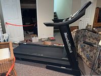 Side view of treadmill showing frame, running deck, and NordicTrack logo