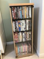 Full front view of the rotating cabinet filled with DVDs visible through glass doors showing multiple shelves.