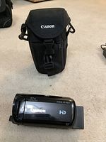 Canon Vixia HF R600 HD camcorder and its black soft carrying case with Canon logo
