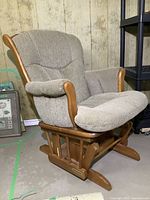 Shermag glider chair angled view showing wood frame and light beige upholstery on cushions and armrests