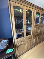 Front view of the solid oak cabinet showing leaded glass doors and solid lower doors with drawer