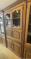 Front side view of the solid oak cabinet showing upper leaded glass doors and lower wooden doors with decorative molding.