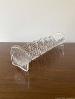 Side view showing detailed fan cut design and clear crystal material on a wooden surface.