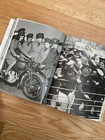 Photograph showing an open page with a black and white image of uniformed women with a motorcycle and another image of a crowd scene in a city.