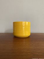Stacked view of 3 yellow Ingrid Ltd. Chicago stackable bowls, showing the round shape and glossy finish.