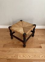 Full angle view of the vintage rush footstool showing woven square seat and wooden legs.