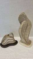 Both South West stone sculptures displayed together on a white surface against a neutral background for scale and comparison.