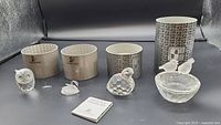 Full lot displayed: 4 crystal animal figurines including an owl, swan, lovebirds on bowl, a single bird, with 4 cylindrical Swarovski branded boxes and a certificate booklet.