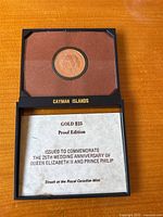 Opened presentation box showing coin in velvet insert and certificate card below
