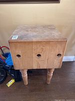 Front view showing three circular cut-out handles in block face and turned legs