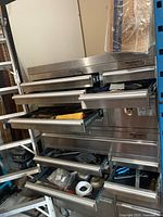 Front view of stainless steel Mechanics Select tool chest with multiple drawers open showing tool contents