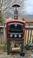 Front view of oven on cart showing glass door, thermometer and three control knobs