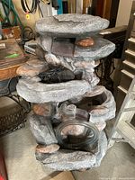 Front view of multi-tiered faux rock water fountain