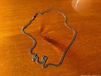 Full view of chain laid on wooden surface showing overall length and condition