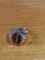Front view of ring showing oval bezel set brown banded stone
