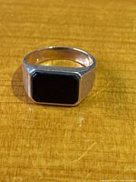Front view of yellow gold signet ring showing rectangular black stone set flush in bezel