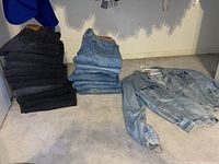 Overall view showing stacks of black and blue jeans with denim jacket to right