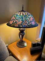 Full view of lamp on wooden table showing shade, base, and overall proportions