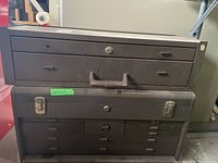 Stacked view of two brown metal toolboxes, drawers and latch locks visible