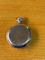 Back of closed silver-tone pocket watch case showing surface scratches