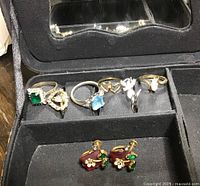 Photo of the six costume rings and screw post earrings in the black padded jewellery box
