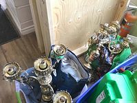 Two brass 5-arm candelabra style lamps in corner, one lamp bag visible alongside with glass globes.