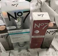 Photo showing all four boxed No 7 products including foundations and serums arranged side by side.