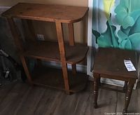 Small vintage wooden three-level shelving unit with rounded shelves and a light wood finish, showing wear and scratches, standing on wood floor.