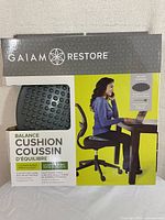 Front view of Gaiam Restore Balance Cushion box with product image and usage example.