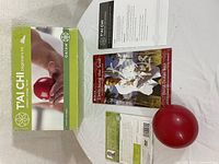 Full lot arranged on a white surface including the DVD box, booklet, and red exercise ball.