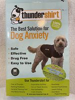 Front packaging showing branding, dog model wearing the gray wrap, anxiety relief benefits and size information.