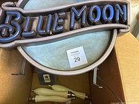 Blue Moon bar sign visible with partial neon-style light tubing, showing wear and paint damage