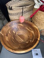 Opalhouse woven basket with tag, wooden salad bowl in front, partial view of Pyrex measuring cup and other baskets