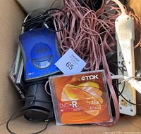 Box contents showing Iomega Zip 250, speaker wire, DVD-R discs, power strip, speakers.