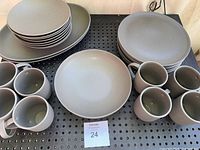 Top view of all dinnerware pieces arranged including plates, mugs, and bowls showing charcoal grey color and finish.