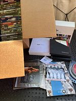 Additional DVDs and loose discs without original DVD cases or covers in a storage box.