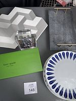 Overview of entire lot including Kate Spade dessert set box, white berry basket, marble serving board, photo frame, and plates.