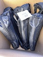 Seven black zippered nylon carry bags for easels packed in a box