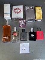Nine assorted perfume and cologne bottles displayed on a surface including boxed and loose bottles.