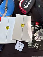Two white boxes with Killerspin logos containing golf paddles, two Under Armour ISO-CHILL golf gloves in packaging, blue rolled sleeping bag, Killerspin black and red zippered paddle cases, visible wader suspenders and apparel in background.