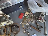 Overview of the vintage Zenith radio, assorted keys, headphones, metal toy car and hand tools arranged on a surface.