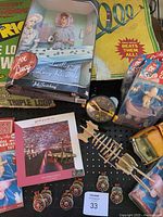 Photo showing a collection of vintage toys including I Love Lucy doll, Tonka dump truck, race track box, alarm clock, puzzle, and other small toys and collectibles.