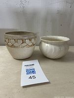 Lot showing both the Weller Pottery Clinton Ivory planter with embossed heart motifs and the Gladding McBean Coronado swirl-form planter side by side.