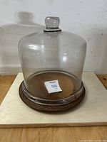 Full view of the glass cloche dome on wooden plate